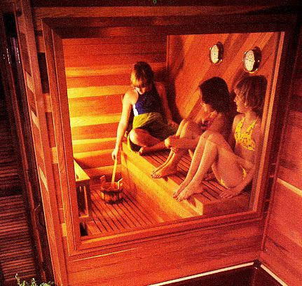 Three girls sitting in a sauna.