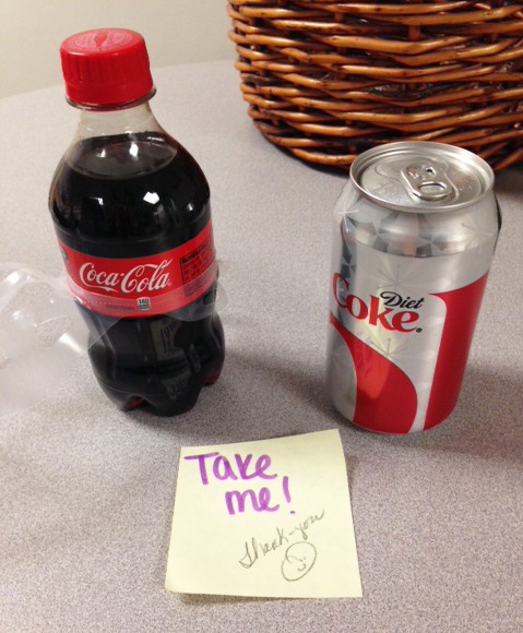 A coke and a diet coke and a note that says "Take one!"